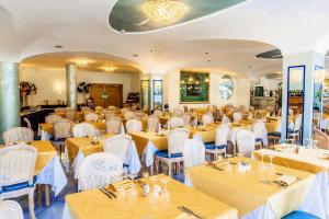 a dining room table with chairs and tables at Aragona Palace Hotel & Spa in Ischia