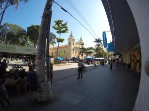 a city street with people walking and a building at Hotel Sao Nicolau in Taubaté