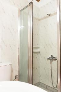 a shower with a glass door in a bathroom at Daskalogiannis Hotel in Loutro