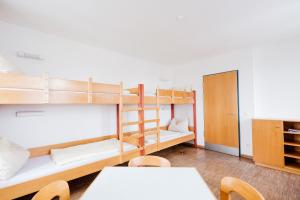 Schlafsaal mit Etagenbetten sowie einem Tisch und Stühlen in der Unterkunft HI Hostel Jugendherberge Passau in Passau