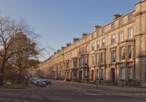 エディンバラにあるThe Edinburgh Address - Drumsheugh Gardensの通路脇に車を停めた大きな建物