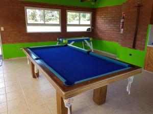 a pool table in a room with green walls at Complejo Don Osvaldo in Sierra de la Ventana