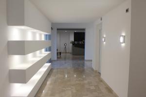 um corredor com paredes brancas e uma escada numa casa em Hotel Miramare em Cirò Marina