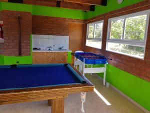 a pool table in a room with green walls at Complejo Don Osvaldo in Sierra de la Ventana