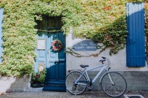 a bike parked in front of a building with a blue door at La Maison Bleue in Villeréal