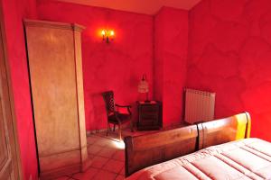 een rode slaapkamer met een bed en een stoel bij Poggio dei cavalieri in Boccea