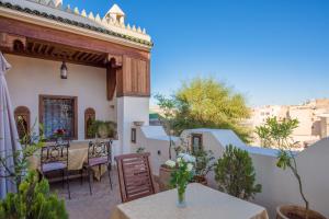 una casa con patio con mesa y sillas en Dar Essoaoude - Fes Nejjarine, en Fez