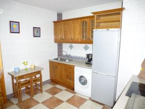 a kitchen with a white refrigerator and a table at Casa Limas in La Iruela