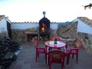 a patio with a table and chairs and a fireplace at Casa Limas in La Iruela