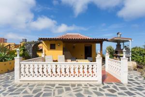una casa amarilla con una valla blanca en El Lagar, en Icod de los Vinos