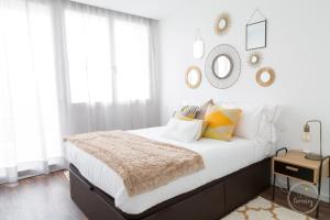 een slaapkamer met een bed met witte muren en ramen bij Hello Porto Ceuta Residences in Porto