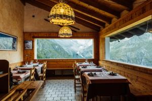 una sala da pranzo con tavoli e una grande finestra di Albergo Ristoro Sitten a Gressoney-la-Trinité