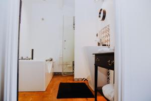 a white room with a black table and a mirror at La Maison Bleue in Villeréal +38 photos