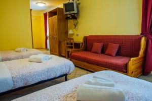 Habitación de hotel con 2 camas y sofá en Albergo Ristoro Sitten en Gressoney-la-Trinité