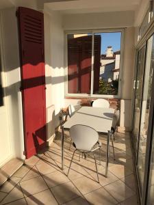 una mesa y sillas en un balcón con ventana en Villa Tricia Cannes, en Cannes