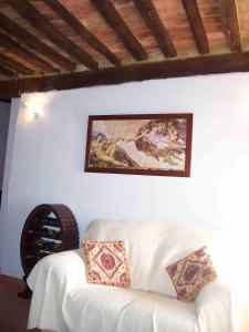 un sofá blanco en una habitación con una pintura en la pared en Casa Romantica Pereta, en Pereta