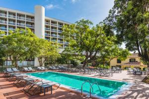 an image of a pool with chairs and a building at Pestana Casino Studios in Funchal