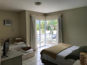 a bedroom with two beds and a sliding glass door at Pousada Vila Verde in Porto Belo +24 photos
