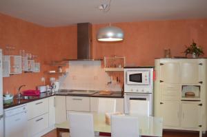 cocina con armarios blancos y nevera blanca en Casa Alfredo, en Villamarciel