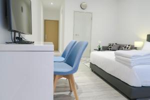 a bedroom with a bed and a blue chair at Comfy Studio 1 by ReCharge in Singapore