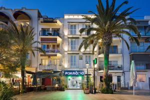a building with palm trees in front of it at Sitges Group Beach Dreams in Sitges
