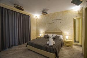 テッラジーニにあるTra Le Braccia di Morfeoのベッドルーム1室(ベッド1台、ナイトスタンド2台、鏡付)
