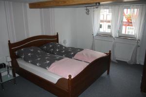 un letto con struttura in legno in una stanza con finestra di Ferienwohnung beim Dünzebacher Torturm a Eschwege