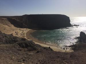 Grupa ludzi na plaży w pobliżu oceanu w obiekcie Trocito De Cielo w mieście Playa Blanca