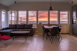a living room with a couch and a table with chairs at Bryggjur in Hvolsvöllur