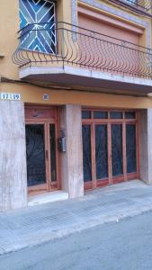 een gebouw met 2 glazen deuren en een balkon bij Casa Pintor in Sant Sadurní dʼAnoia