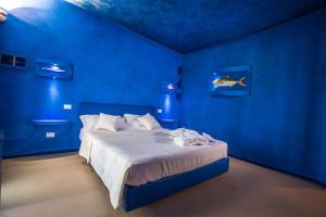 a blue and white bed in a room with a blue wall at Tra Le Braccia di Morfeo in Terrasini