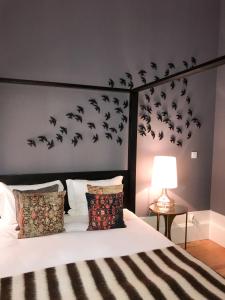 ポルトにあるOporto Chic & Cozy - Floresのベッドルーム1室(壁に鳥の群れが描かれたベッド1台付)