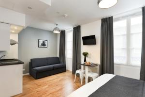 una camera da letto con un letto, un divano e un tavolo di Hotel Résidence Montebello a Parigi