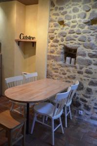 Mortagne-sur-SèvreにあるGîte "L'Ame d'Antan" 5 personnes proche puy du fouの石壁の前に木製のテーブルと椅子
