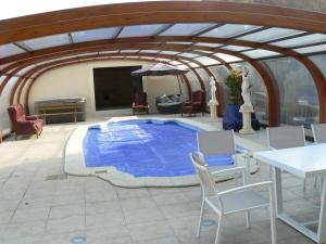 沃努瓦的住宿－茶皮勒斯拉曼諾爾德酒店，一个带桌椅的房间,有一个蓝色的大游泳池