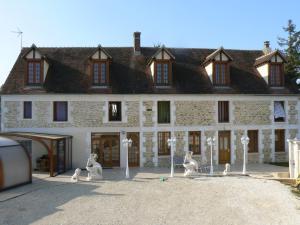 a large white building with statues in front of it at Le Manoir des Chapelles in Venoy