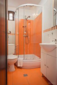 an orange bathroom with a shower and a toilet at Pensiunea Daiana in Mamaia Nord