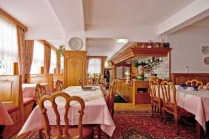 a dining room with tables and chairs and a kitchen at Burghotel in Monschau