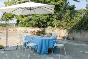 Montorio Veronese的住宿－魯古拉納住宿加早餐旅館，一张带椅子的蓝色桌子和一把雨伞