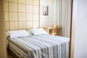 una camera con un letto con una coperta a righe di Américas Gaivota Hotel a Rio de Janeiro
