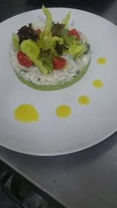 Un plato blanco con una ensalada. en Le temps perdu en Oualidia