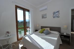 een witte slaapkamer met een bed en een raam bij Mavi Apartments in Piano di Sorrento
