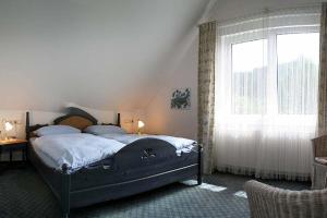 a bedroom with a bed and a large window at Landhaus Mühlenberg in Willingen