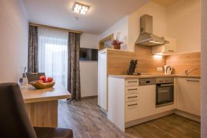 - une cuisine avec un comptoir et une table avec un bol de fruits dans l'établissement Appartements Viteritti, à Mayrhofen