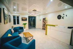 a waiting room with blue chairs and a table at Hotel Sani Kutaisi in Kutaisi