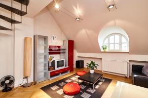 een woonkamer met een bank en een tv bij Prague Letna Apartments in Praag