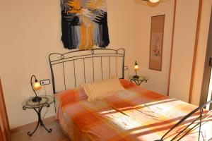 - une chambre avec un lit avec deux tables et un tableau mural dans l'établissement Saval Cala Font, à Salou