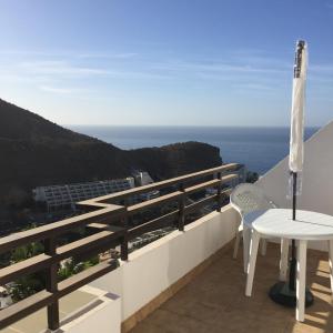 balcón con mesa, sillas y vistas al océano en Apartamento Jacaranda en Puerto Rico