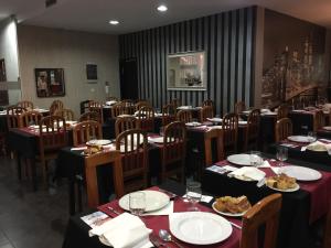 una sala da pranzo con tavoli e sedie con cibo sopra di Fiel Chef Alojamento Local a Valongo