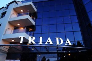 a tall building with a sign that reads trilateral at Triada Hotel in Sofia